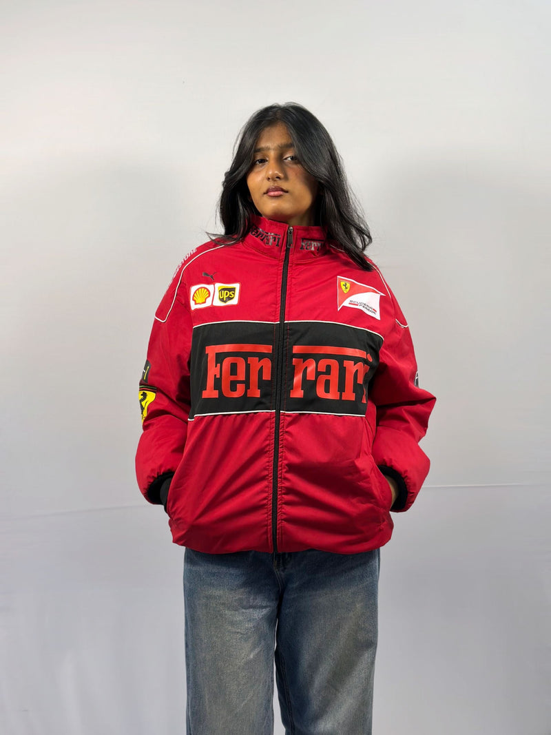 Red unisex puffer jacket with Ferrari F1 logos and black front panels, full zip.