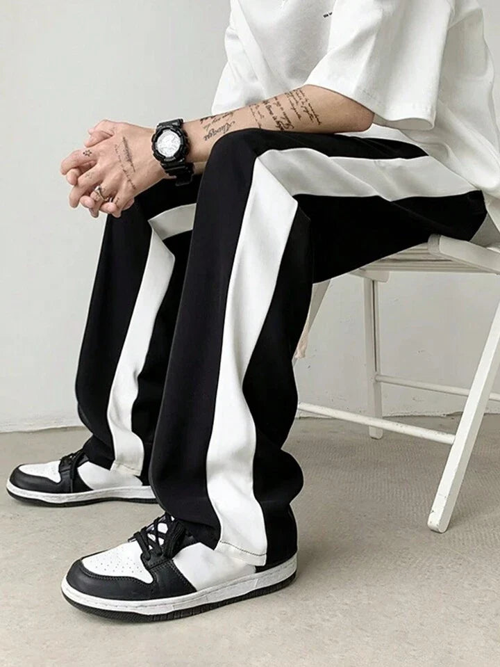 Black track pants with wide white side stripe, relaxed straight fit, stylestitch