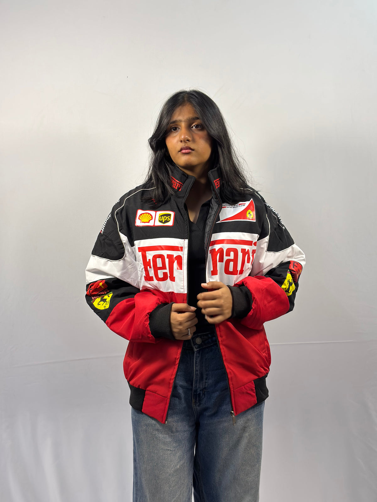 Unisex puffer jacket with black and red color-blocking, logo patches, and zip front
