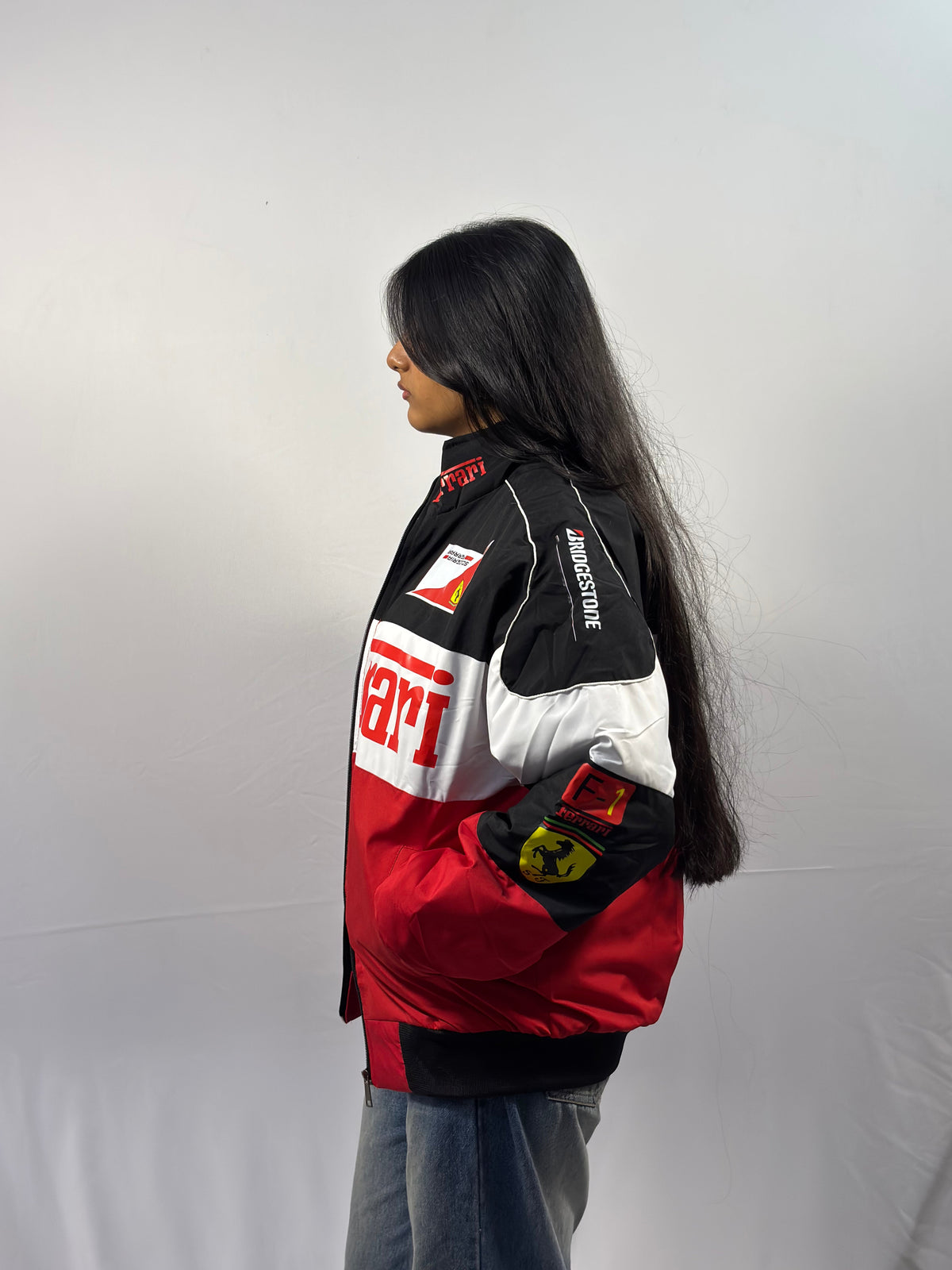 Unisex puffer jacket with black hood, red hem, and sponsor patches on sleeve